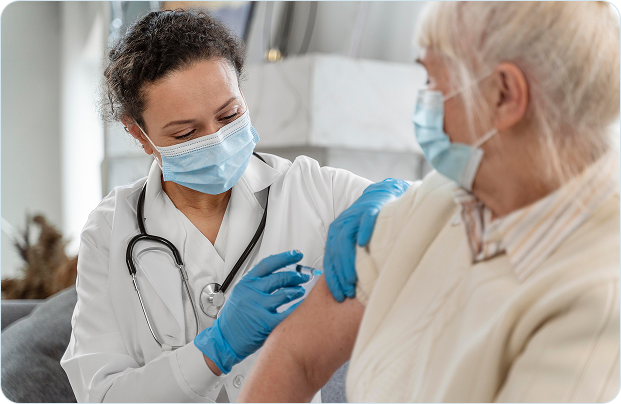 Médica aplicando vacina em paciente idosa